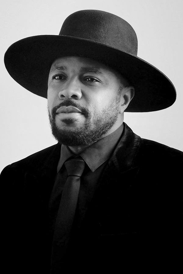 DJ D-Nice in a hat and suit