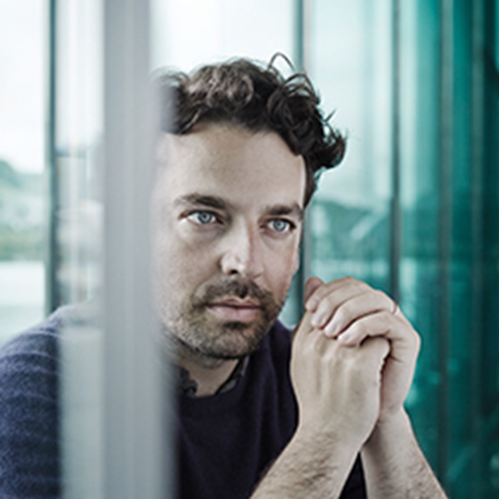 James Gaffigan sitting with hands folded near his face