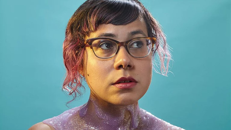 Angélica Negrón covered, neck down, in pastel purple glittery jelly