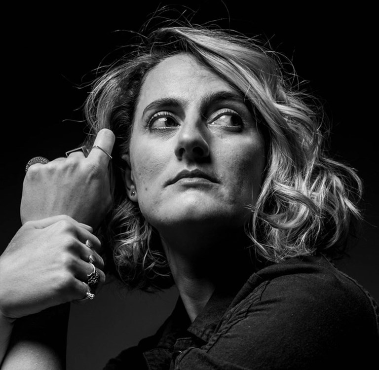 Britta Joy Peterson with hands close to her pondering face. Photo  by Maria Miranda