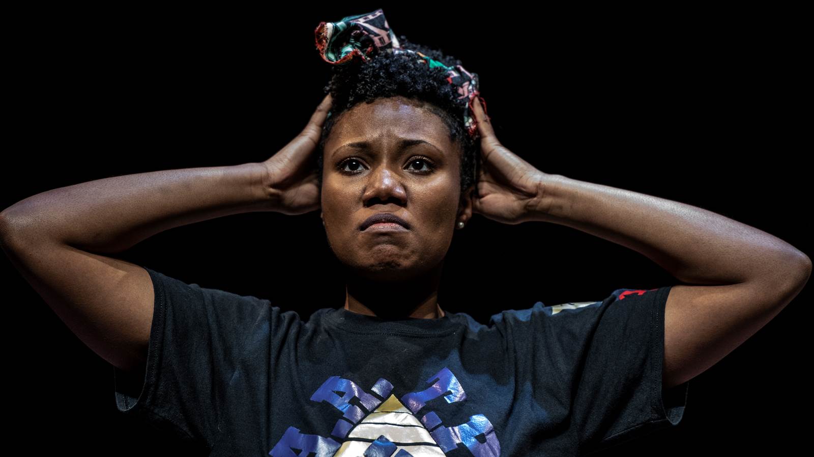 A close up of a young black female actor straightening her hairband.