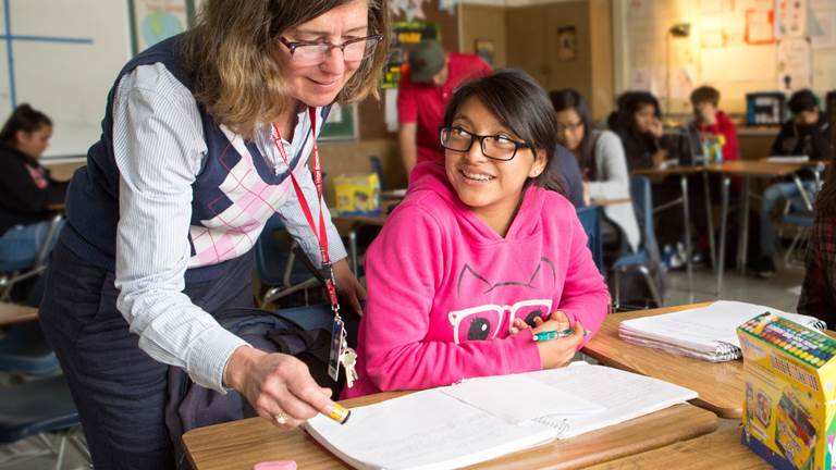 A teacher looks over her student's work