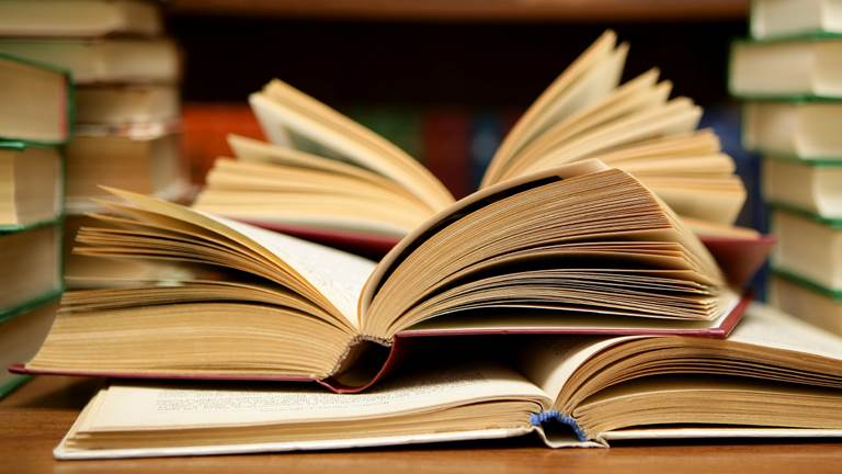 An open book lying among other books