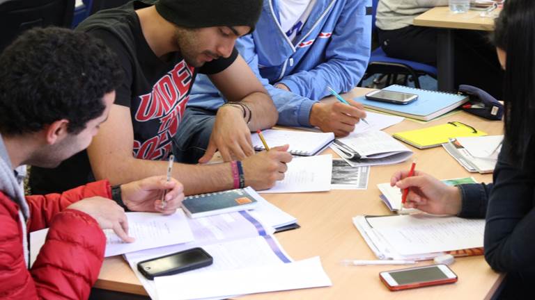 Students sitting at a table together working on school work