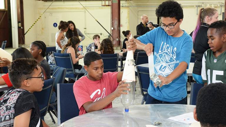 Three students work together on a science project in class