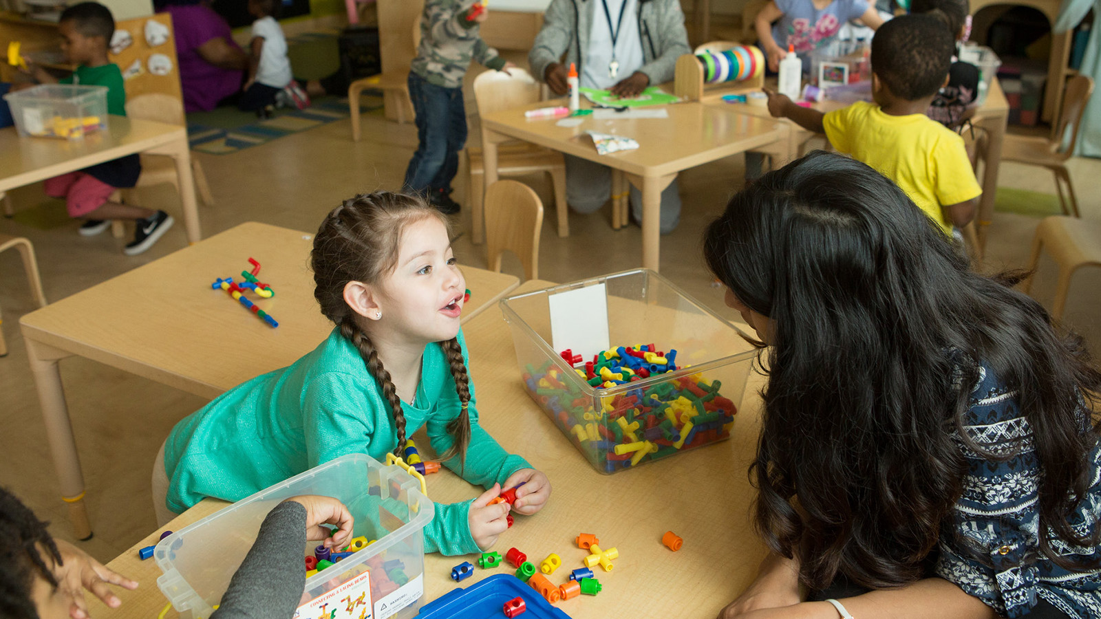 A Child Using Math Manipulatives and Talking to Teacher.jpg
