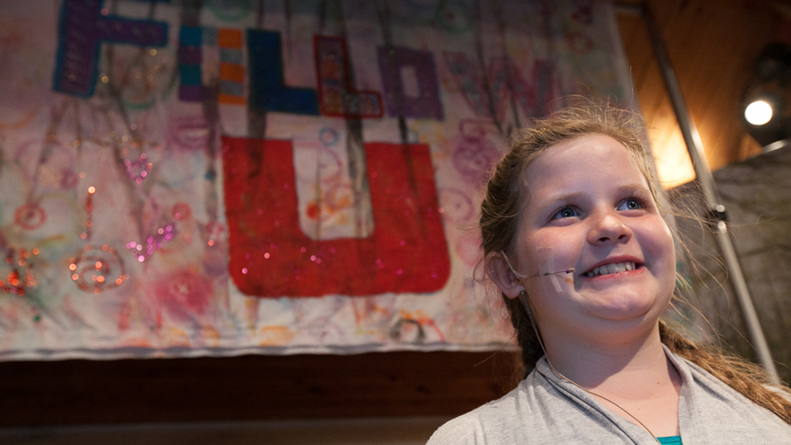 A Smiling Child With a Wireless Microphone.jpg