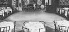 A black-and-white photo of the inside of Connie&rsquo;s Inn. There are several round tables, each with four chairs, surrounding a centralized empty dance floor.