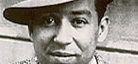 A black-and-white photo of writer Langston Hughes wearing a brimmed hat.