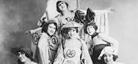 A cropped black-and-white image of Black cast members of the 1921 musical, Shuffle Along. Featured are four women posed together wearing 1920s fashionable hats, short hair, and outfits.