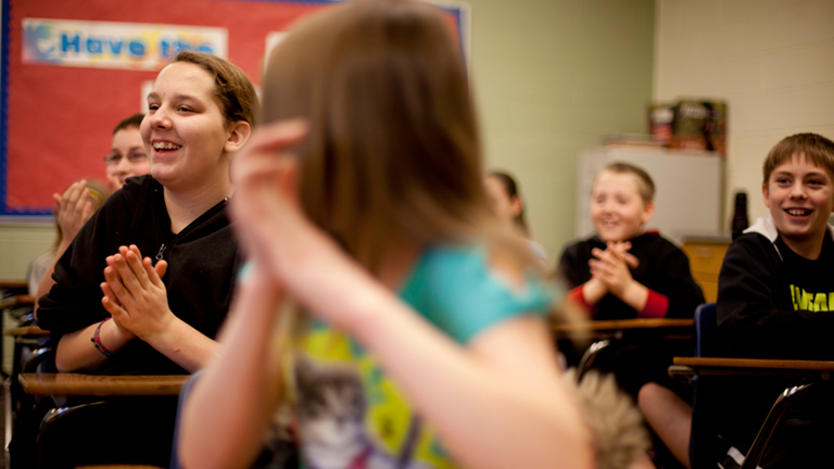 A group of students clapping a rhythm. 