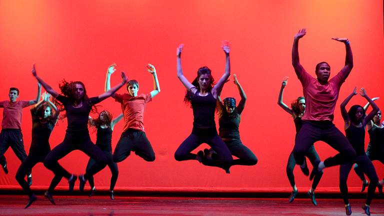 A group of youth dancers performing on a stage.