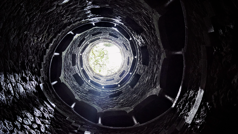A spiral staircase made of stone in Sintra, Lisboa, Portugal. The staircase is named "Initiation Wells". 