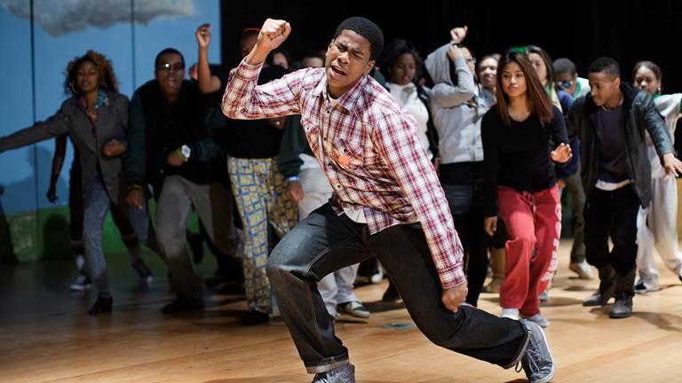 An actor using dramatic gestures and expressions during a performance. 