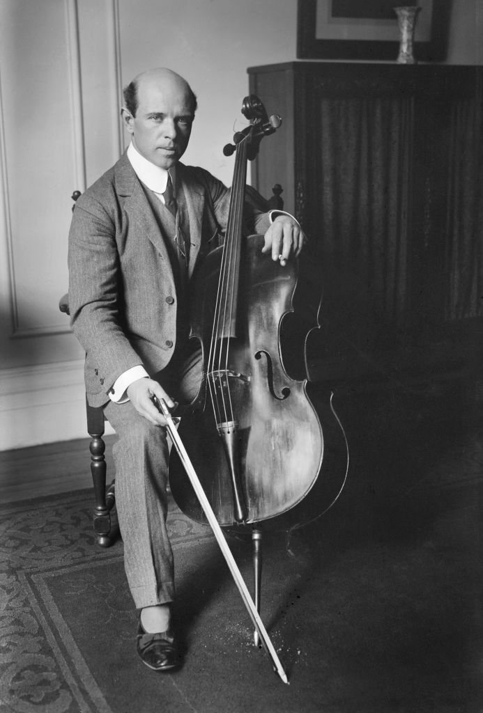Black and white photo portrait of Pablo Casals sitting with his cello at Carnegie Hall in 1917.