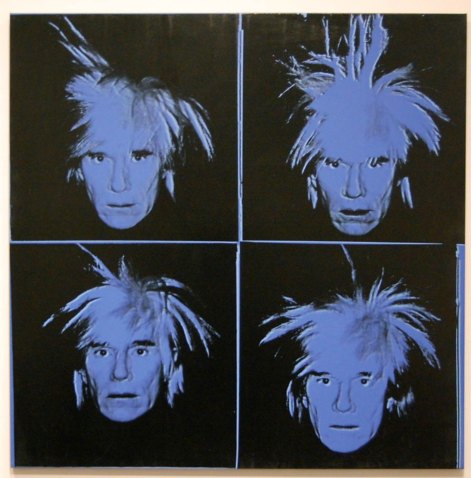 Four blue-colored similar photographs of a man's head with spiky hair