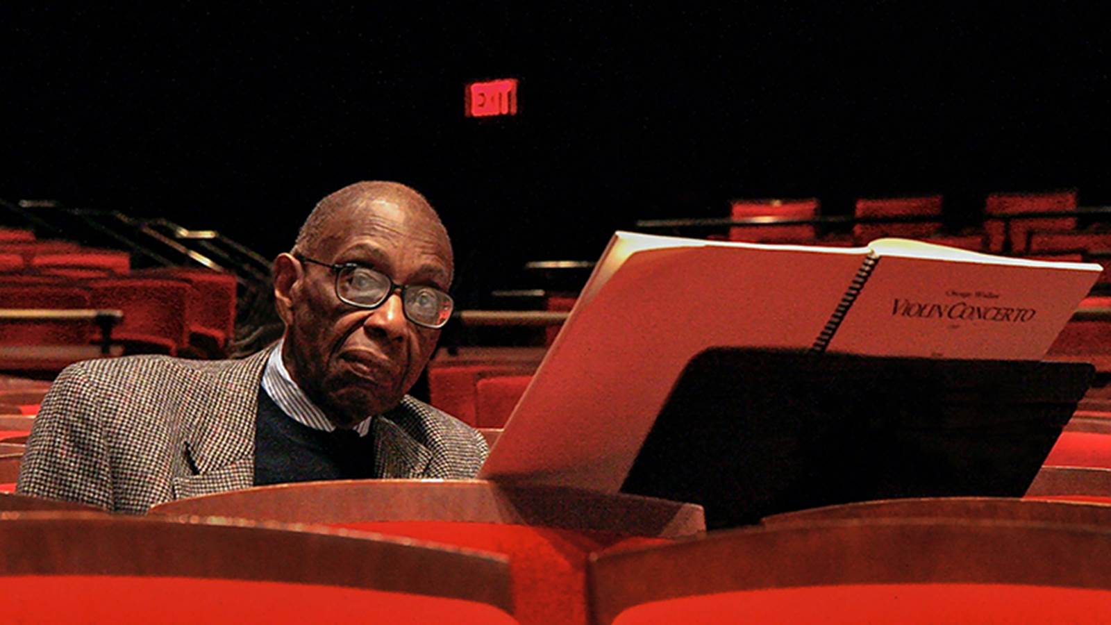 Walker at piano with violin concerto score