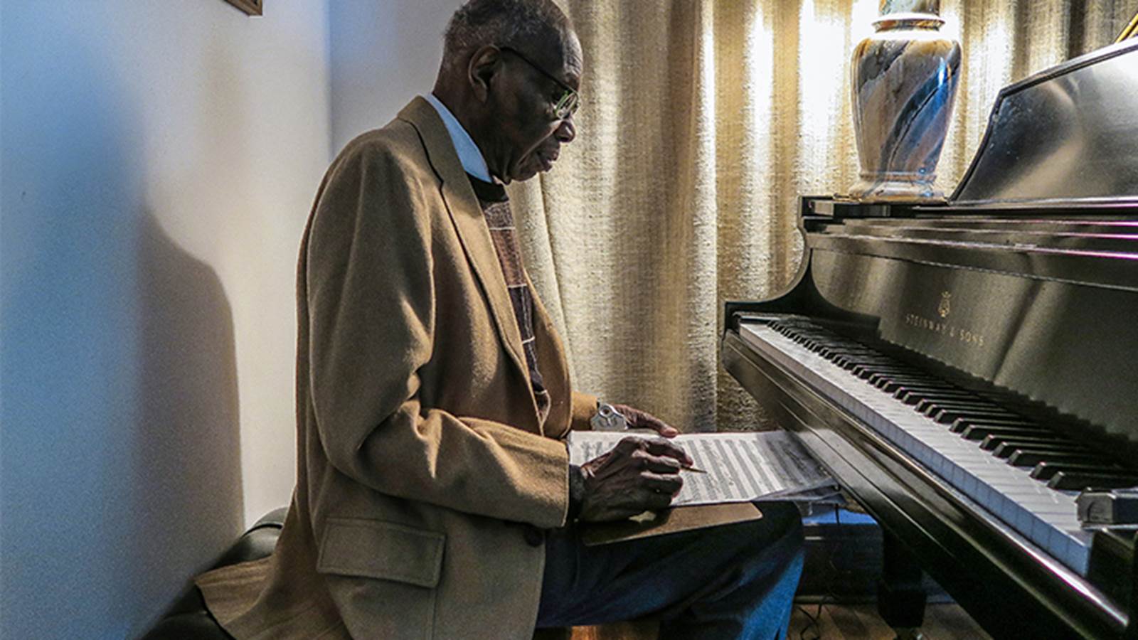 George Walker at piano with score