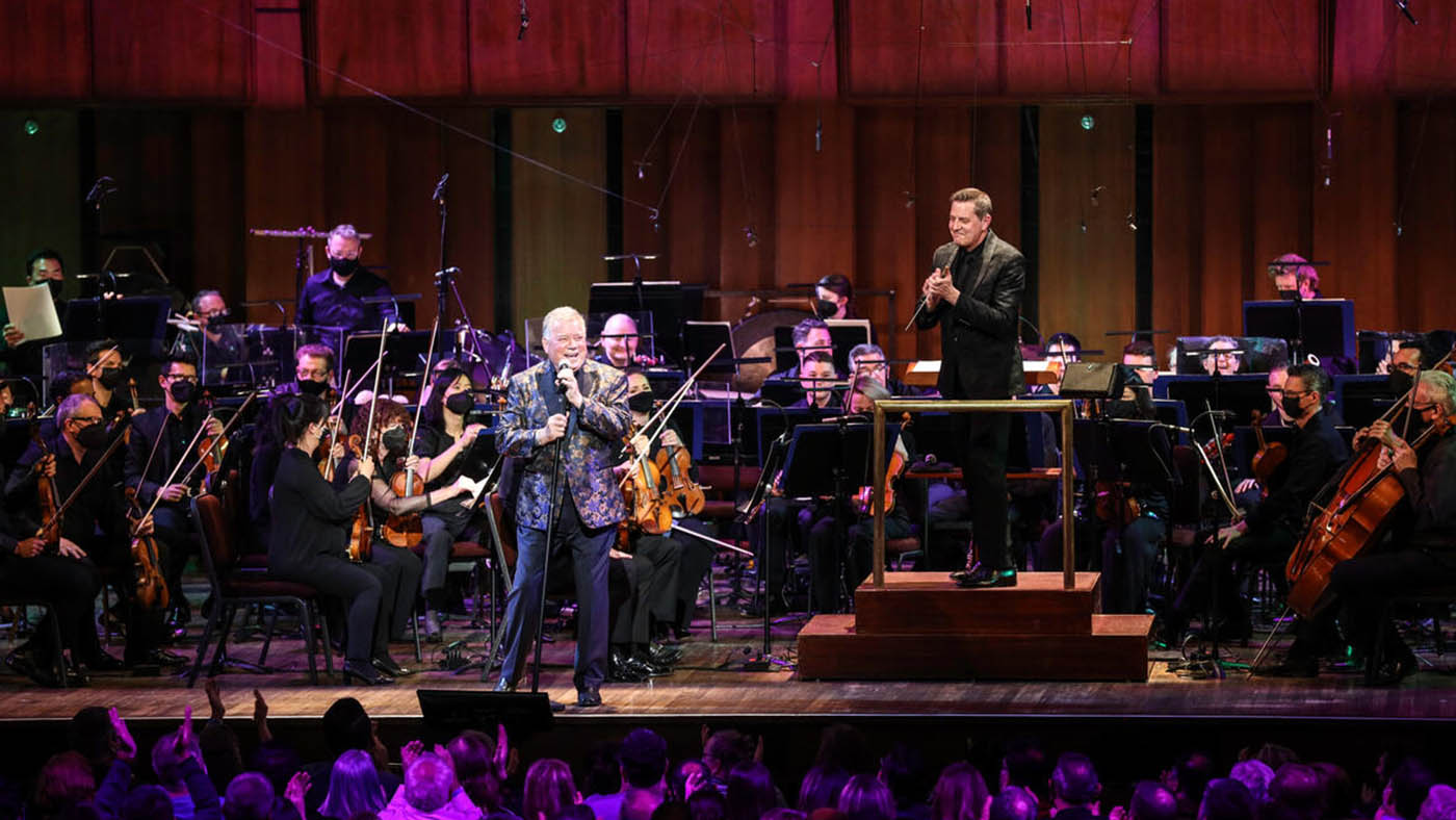 William Shatner singing with NSO while Steven Reineke  is smiling.