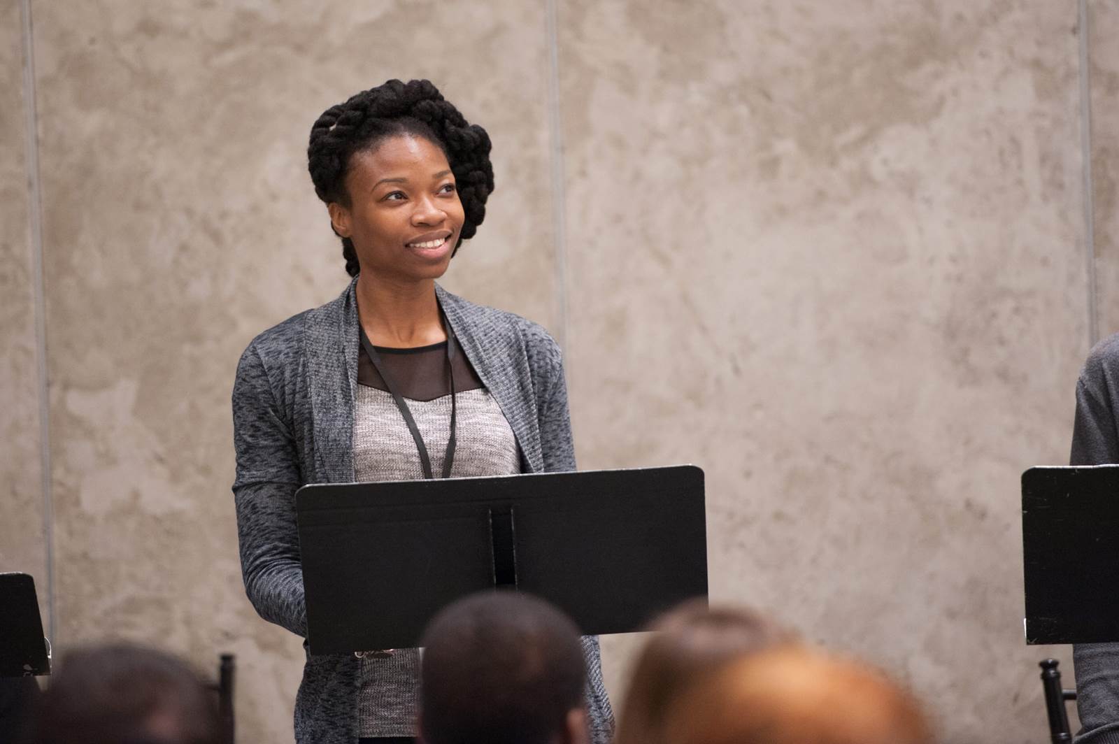 A woman stands at a music stand for a reading