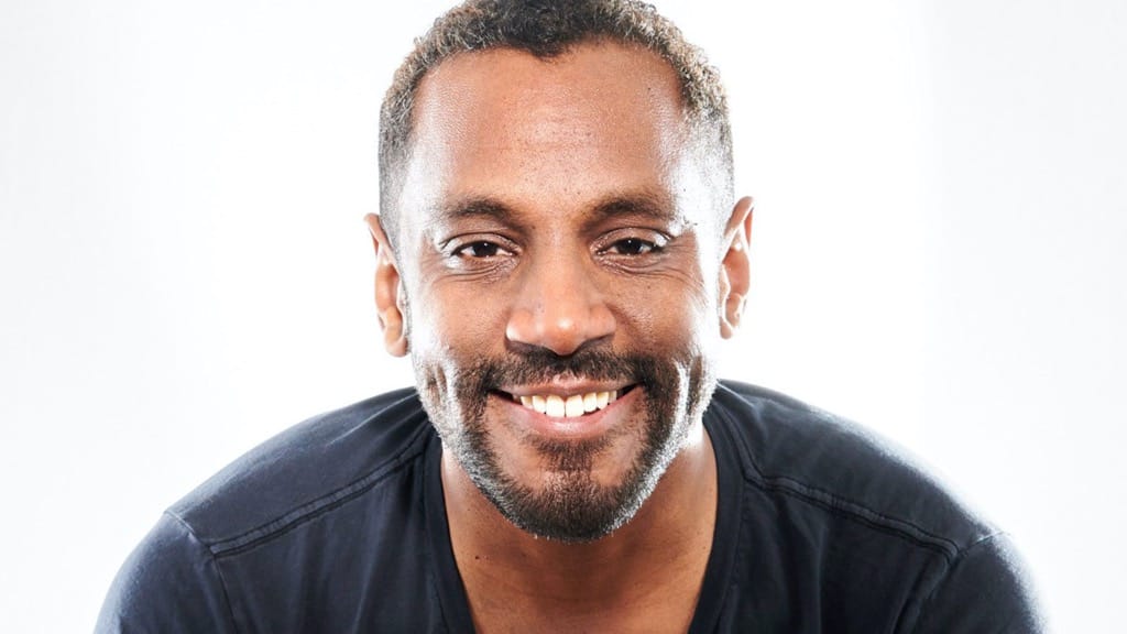 Composer Carlos Simon smiles into camera