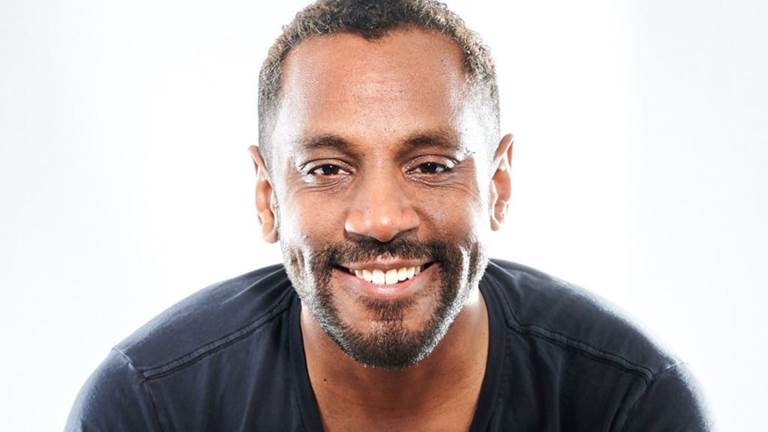 Composer Carlos Simon smiles into camera