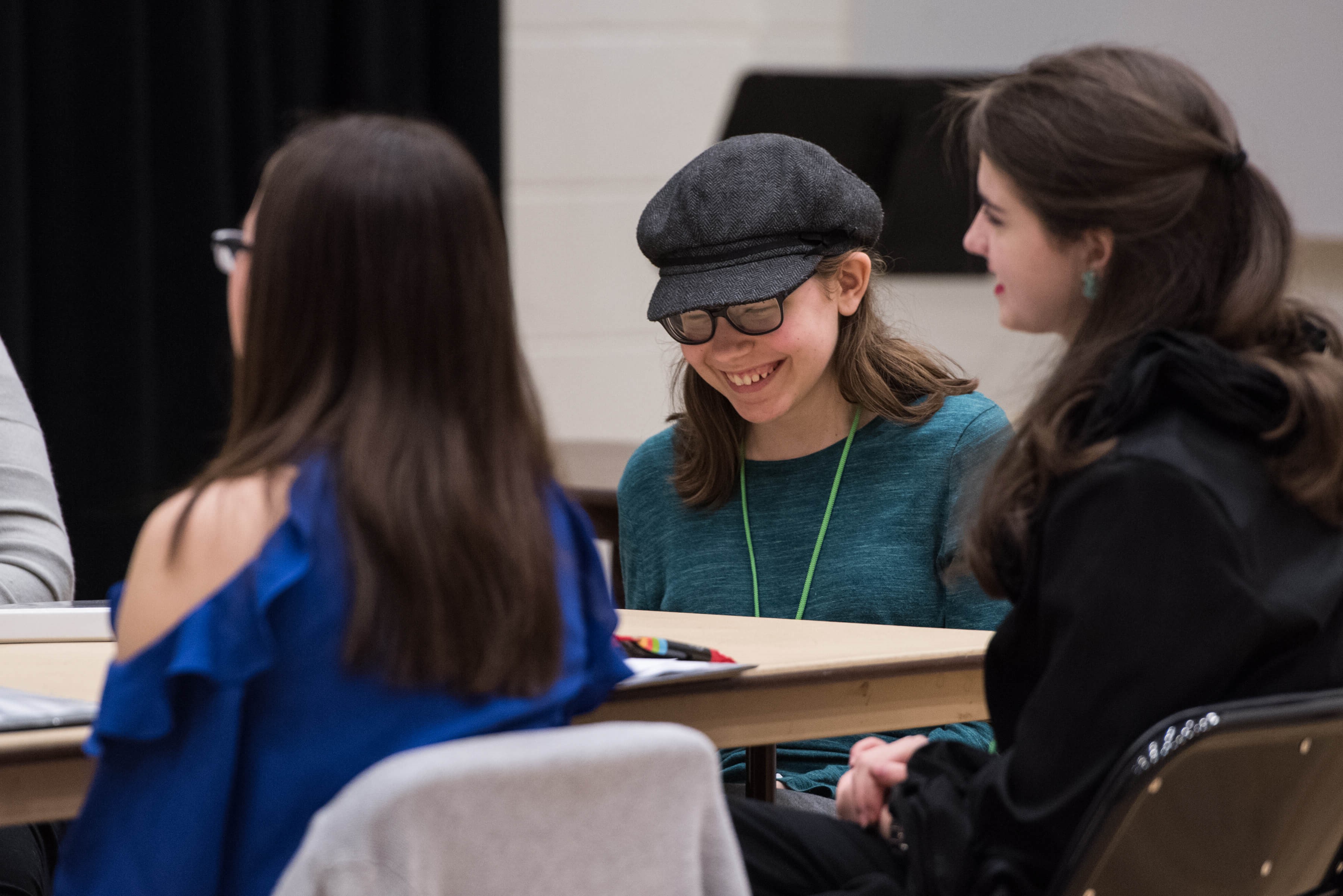 Very Special Arts participants read a script around a table