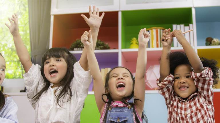 Kids with thier arms up sining with joy
