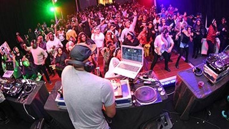 DJ with room full of audience dancing